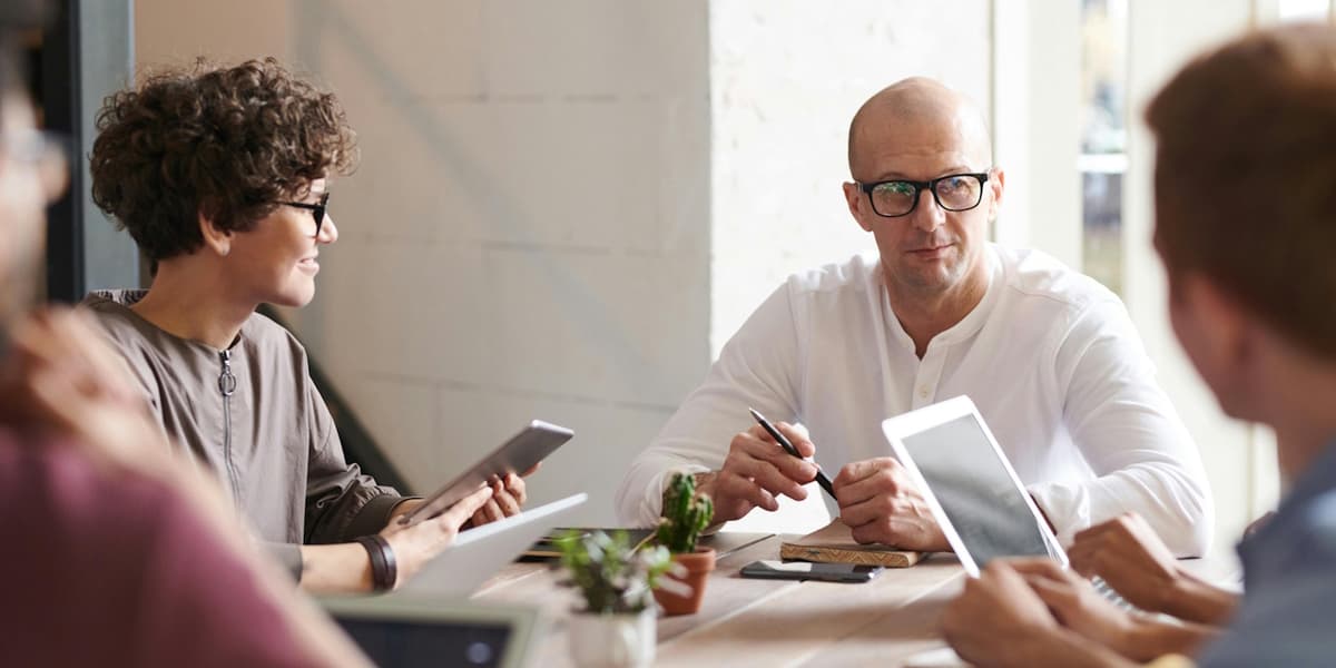 Business executives discussing fractional vs interim CIO strategies in modern office